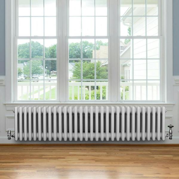 Traditional 4 column radiator in white, 300 x 1370mm, featuring a sleek design, installed under a large window with natural light