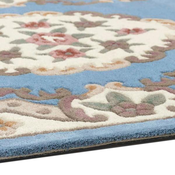 Close-up of a floral-patterned rug with blue and beige colors.
