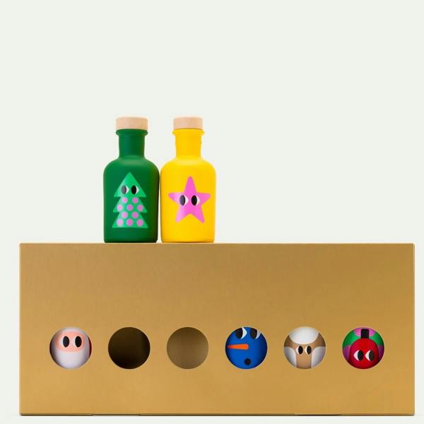 A gold Christmas mini olive oils gift box showing character bottles inside with a green tree and yellow star bottle on top.