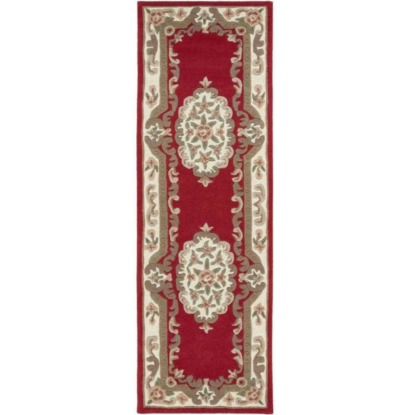 Decorative red and beige runner rug with intricate patterns on a white background