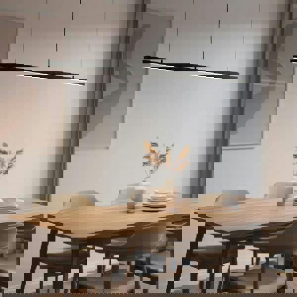 Black linear pendant light fixture above a table in a modern home