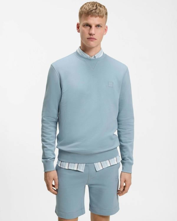 Model wearing BOSS Orange Westart Mens Crew Neck Sweatshirt With Logo Patch in Light/Pastel Blue 458 - Front
