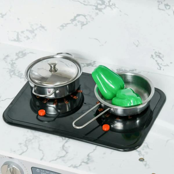 Toy stove top with two metal pots on black cooktop and orange knobs, green pot insert