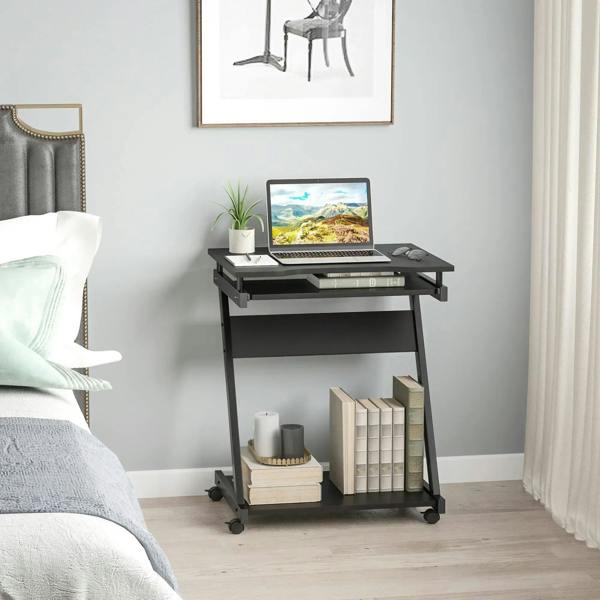 Black rolling computer desk with slide-out keyboard tray in a home office setting