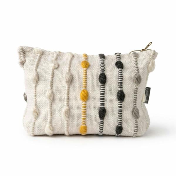 Nomad Sari jacquard toiletry bag, cream fabric with striped pom-pom trim and top tie.