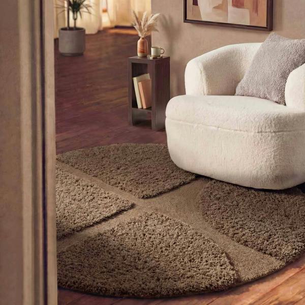 Brown checkered rug in a living room with a white armchair and side table.
