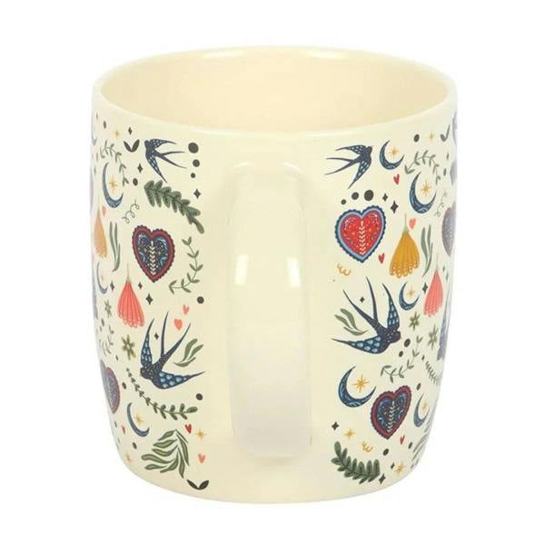 Cream mug with blue bird, red hearts, and small leaf details