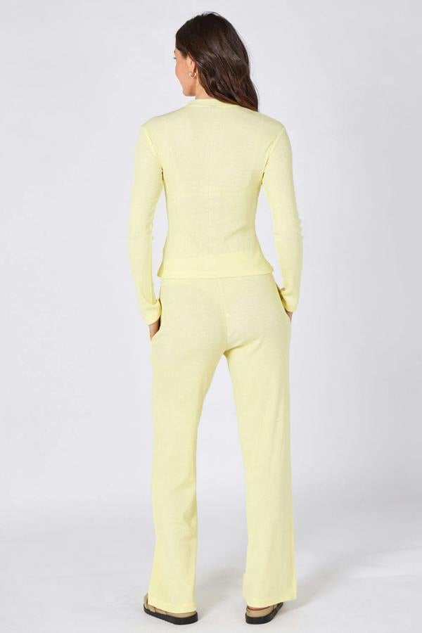 Woman wearing a light yellow suit on a white background