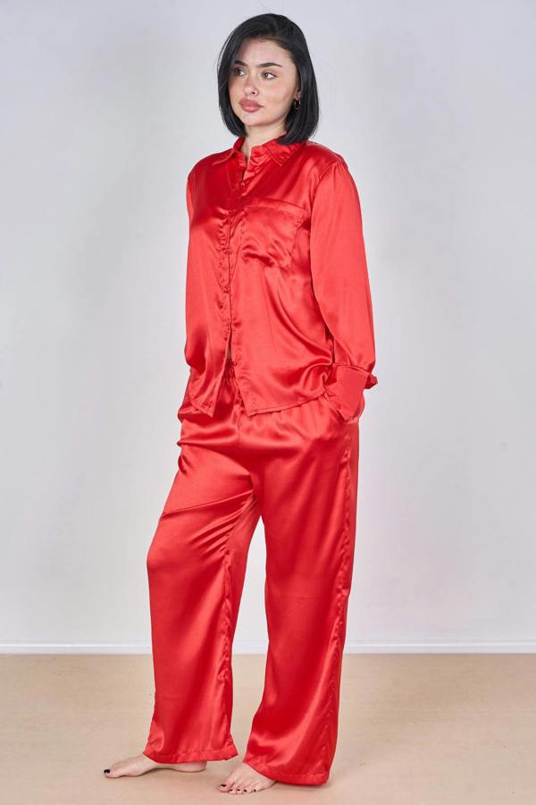 Person wearing a red satin pajama set against a white background