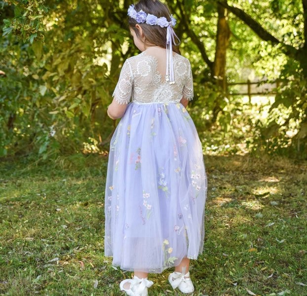 Young girl in a floral dress standing in a garden