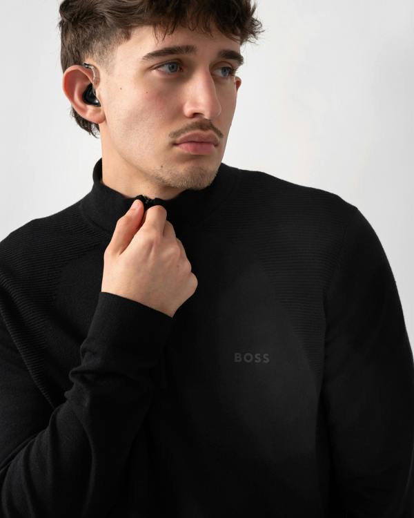 close up shot of a model wearing a BOSS Green Momentum-Lite Mens quarter Zip Funnel Neck Jumper in Black 001