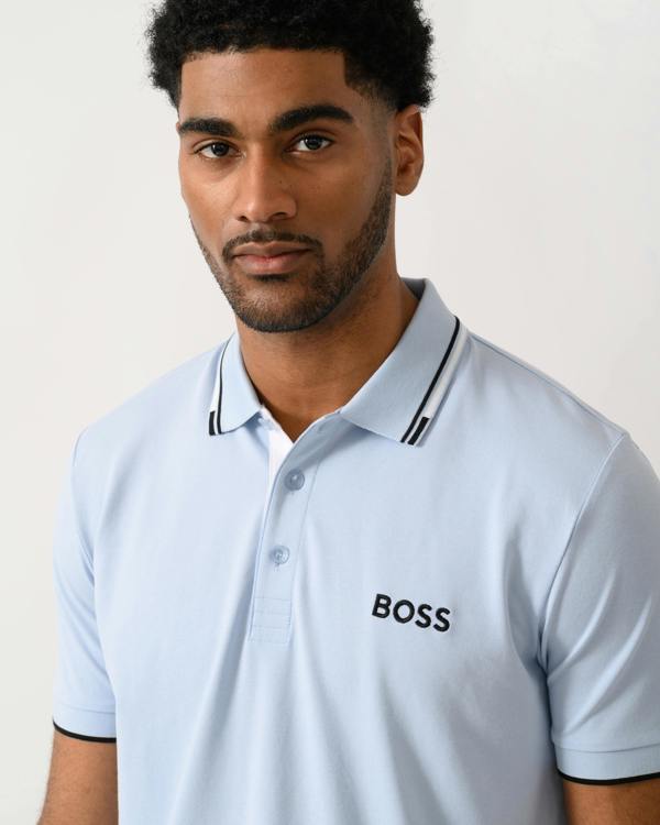 detail shot of a model wearing a BOSS Green Paddy Pro Mens Cotton Blend Polo Shirt With Contrast Logos in Open Blue 460