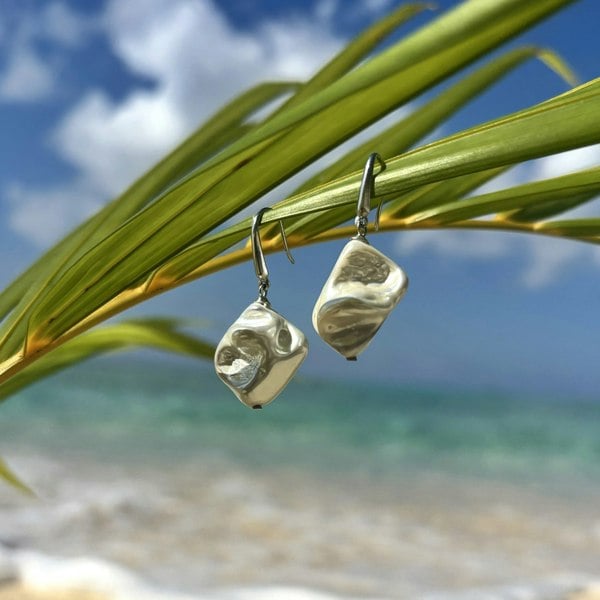 Silver natural shell earrings handcrafted in London by LENAE shot on a castaway island.