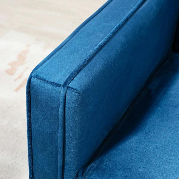 Blue sofa bed armrest and corner seam in velvet-feel polyester upholstery close-up