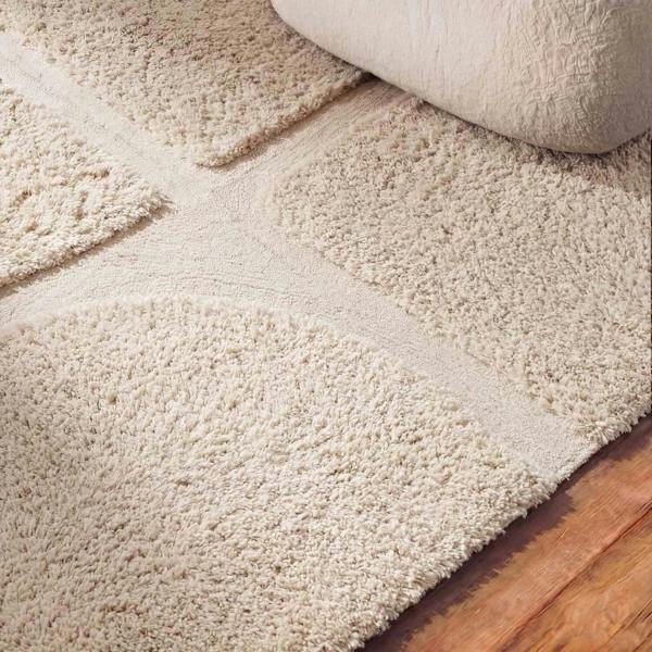 Beige carpet being rolled out on a wooden floor
