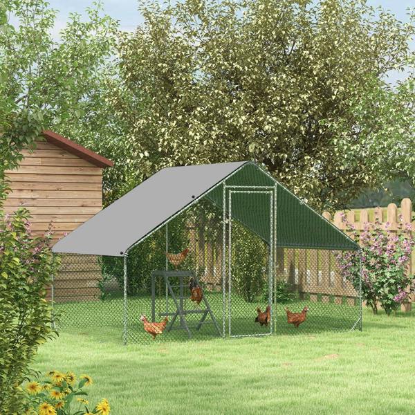 Outdoor chicken coop with dark grey roof cover and wire mesh walls, front door visible