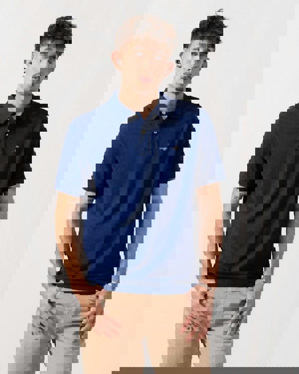 Model wearing GANT Mens Regular Fit Short Sleeve Shield Logo Pique Polo in 432 Rich Navy - Front