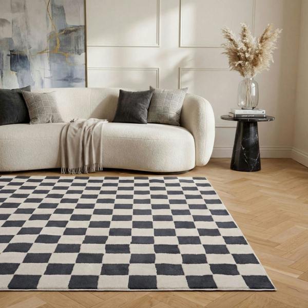 Living room with a checkered rug, beige sofa, and abstract art on the wall.