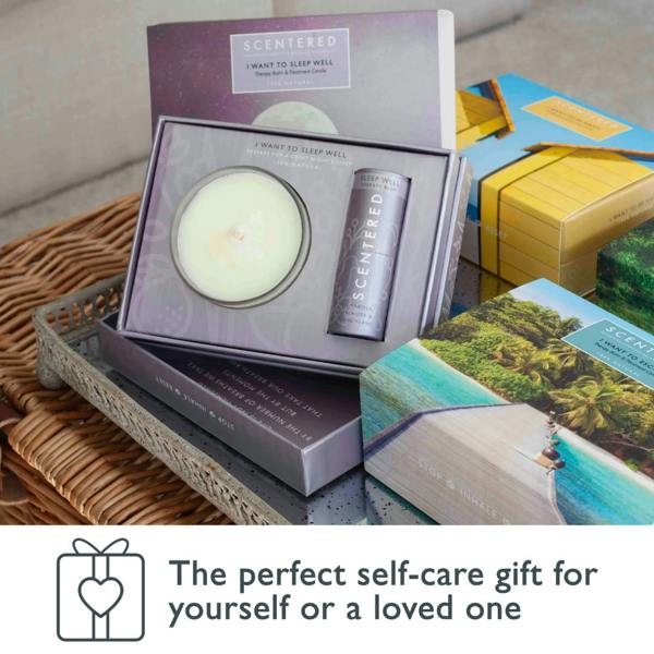 Scentered Sleep Well candle and therapy balm gift set displayed in a wicker tray alongside other Scentered collections, with text reading ‘The perfect self-care gift for yourself or a loved one.