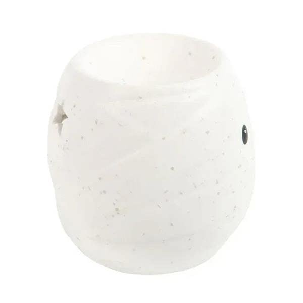 White ceramic mummy-shaped oil burner with black dot eyes, sculpted rounded body