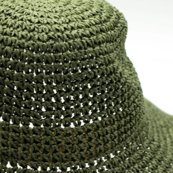 Close-up of moss green woven straw texture with horizontal stitching rows