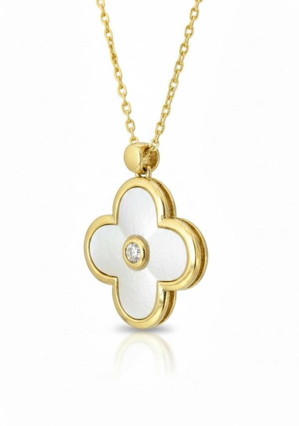 Gold necklace with a white flower-shaped pendant on a white background