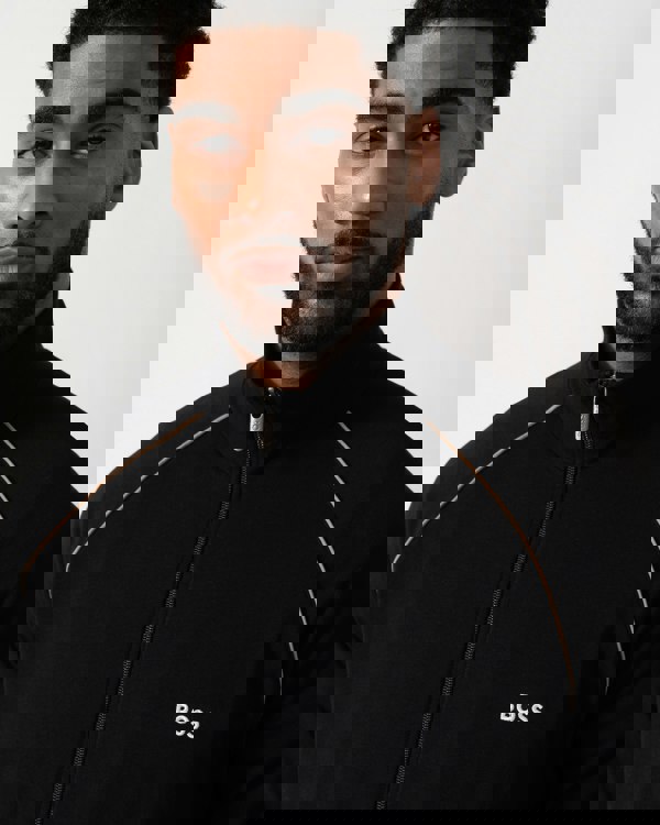 Close up shot of a Model wearing a BOSS Orange Mix&Match Mens Logo-Embroidered Full Zip Loungewear Jacket in black Stretch-Cotton Jersey