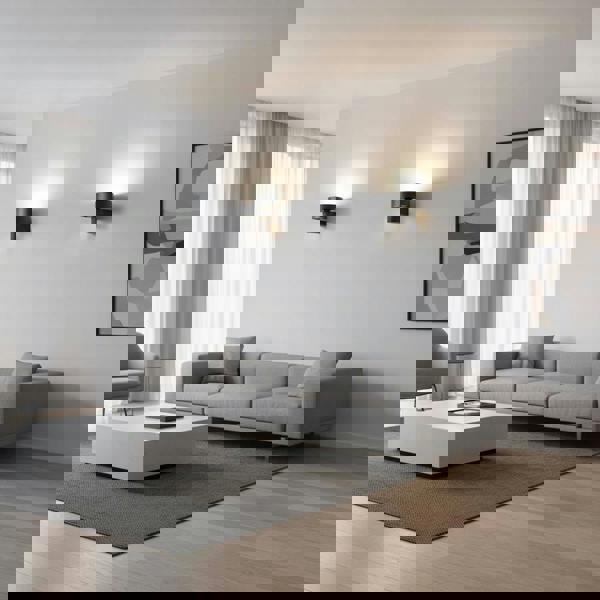 Black wall mounted interior light fixture on one wall above a sofa in a modern longe