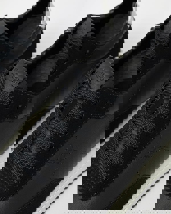 Black sneakers with 'BOSS' branding on a white background