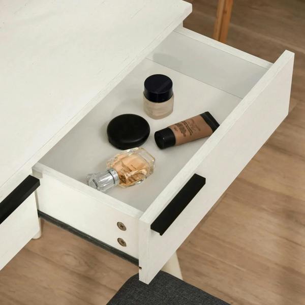 Open vanity drawer with black handles and beauty accessories