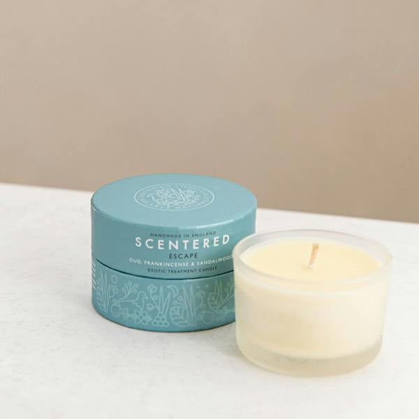 Scented candle with blue gift box  on a desk.