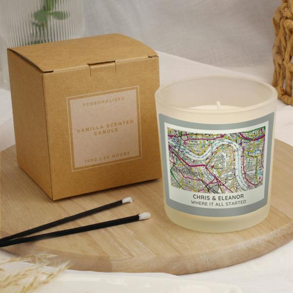 A lifestyle product shot from P0512AA07_3.jpg showing the unlit custom map jar candle paired alongside its rustic kraft paper gift box, displaying the vanilla scented product details and clear typography.