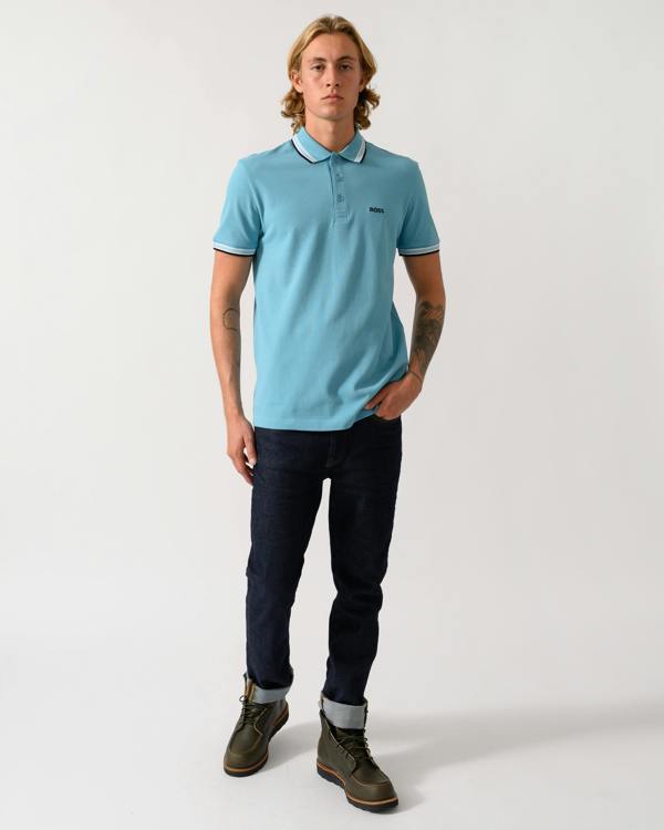 full length studio photograph of a model wearing a BOSS Green Paddy Mens Cotton-Piqué Polo Shirt with Contrast Logo in Open Blue 486