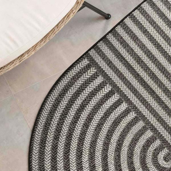Round black and white striped rug on a light gray floor.