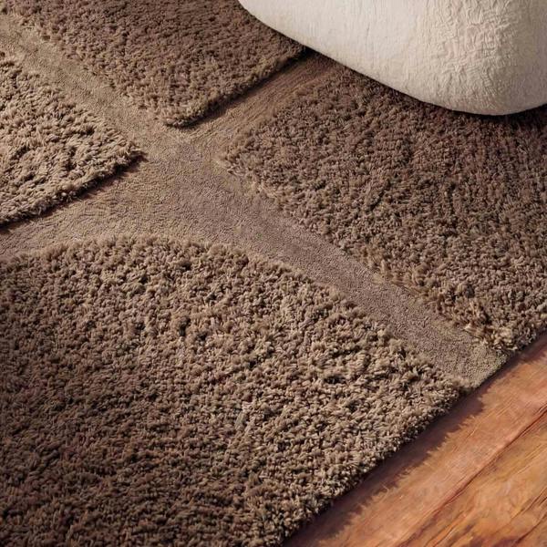 Brown textured rug on a wooden floor