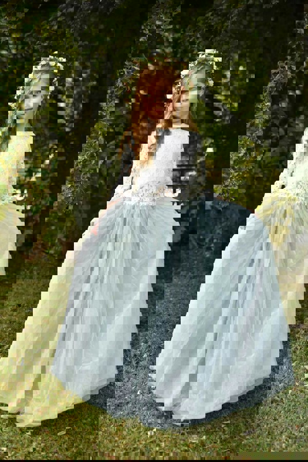 young girl standing holding her dress