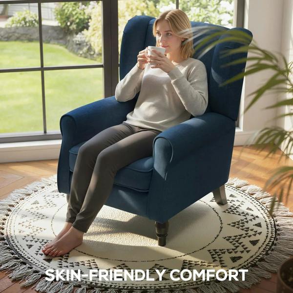 Blue wingback accent chair with tufted back and cushioned seat, shown with seated person.