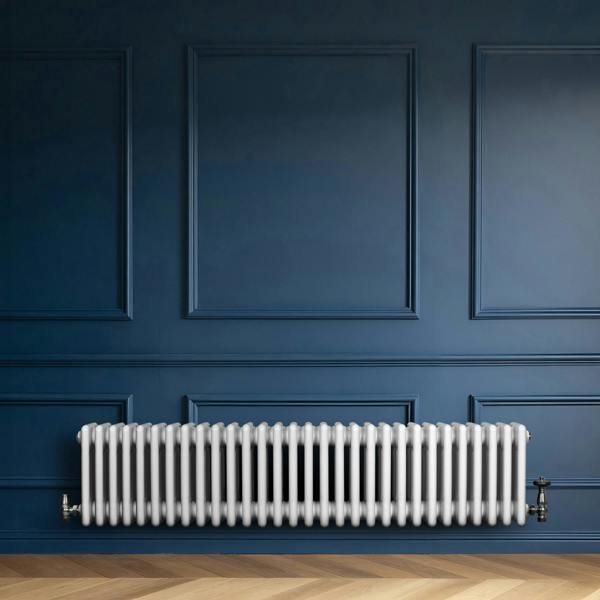 Traditional white 4 column radiator, 300 x 1370mm, installed against a deep blue wall, showcasing a sleek, modern design and smooth finish