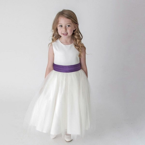 Girl in ivory party dress with purple sash