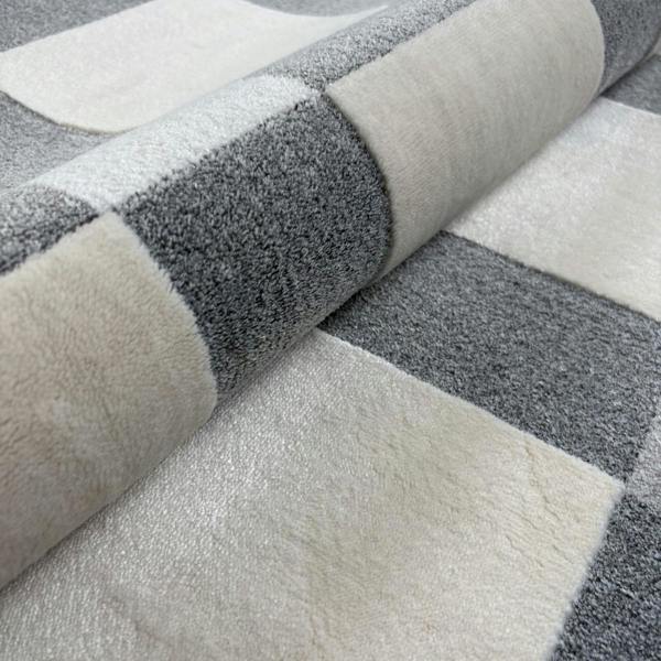 Close-up of a gray and white checkered patterned rug.