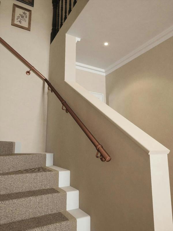 Sambourne Antique Copper Single Winder Handrail wtih a view of brackets and elbow showing a left turn
