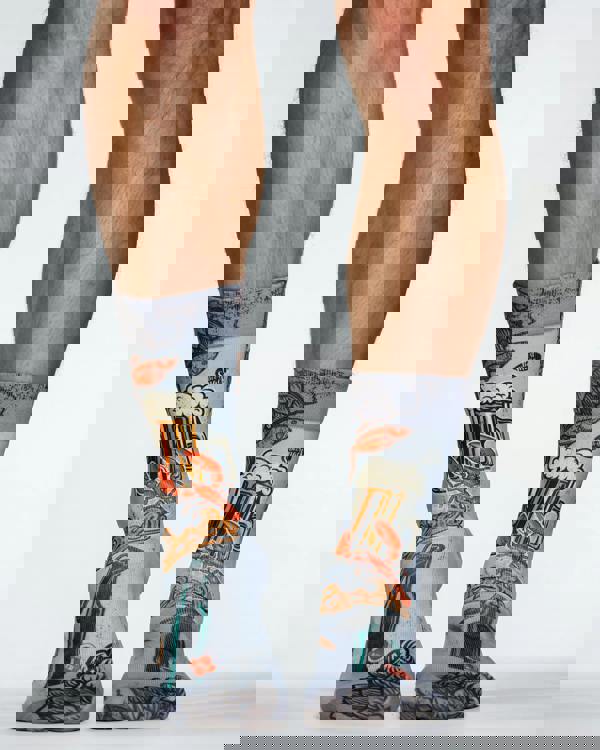 Gray socks with beer-themed design worn by a person on a white background