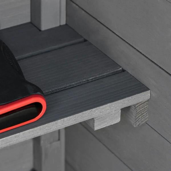 Dark grey wooden storage shed shelf with tools resting on it