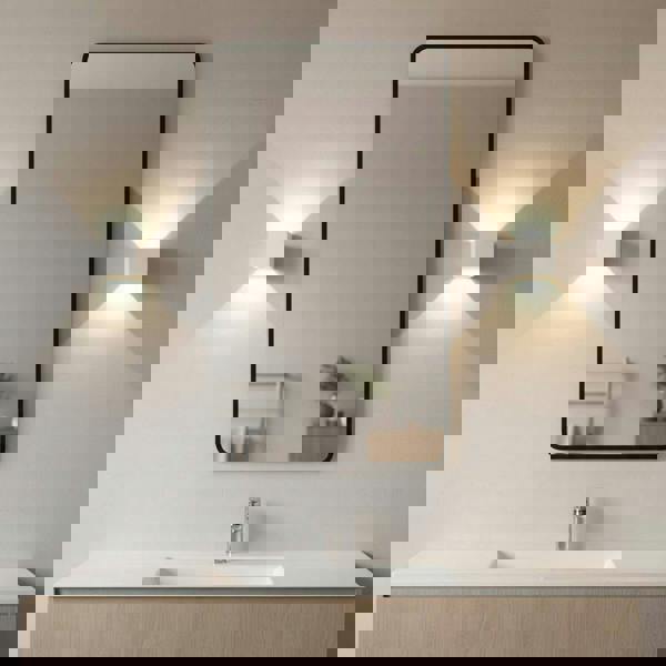 white modern bathroom wall light mounted either side of a bathroom mirror