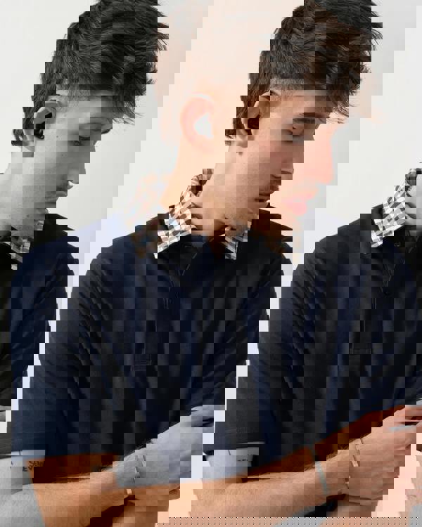 close up shot of a model wearing an Aquascutum Mens Club Check Collar Polo Shirt in Navy 11