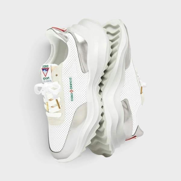 Supplied Fashion Atlantis sneaker in white with chrome accents, featuring a perforated leather upper and chunky sole.