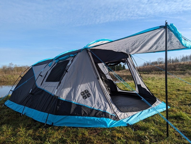 the Stafford 3.0 OLPRO x Ed Stafford on a patch grass next to a lake. Against a blue sky.