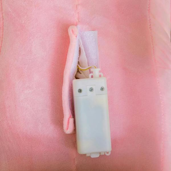 Pink plush seat with white music/control panel attached on ride-on toy