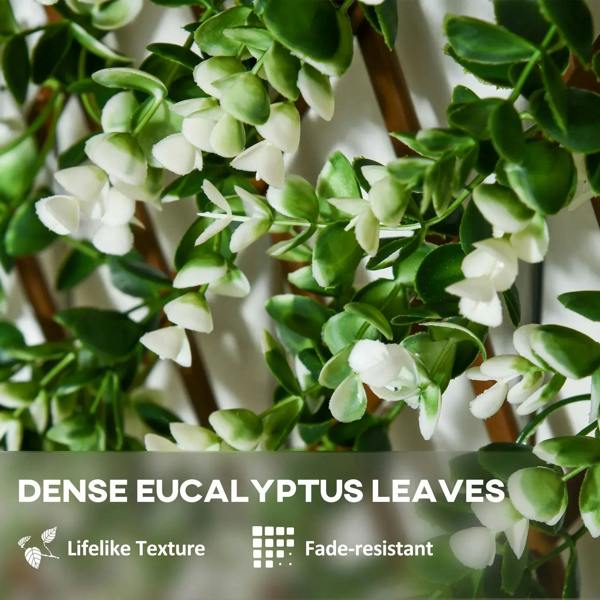 Dense eucalyptus-style artificial leaves on a green faux trellis screen
