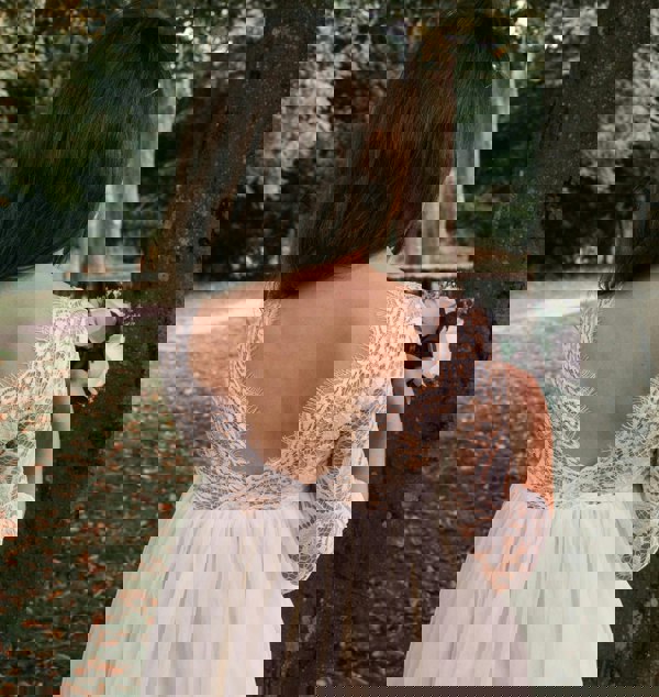 young girl holding flowers by tree